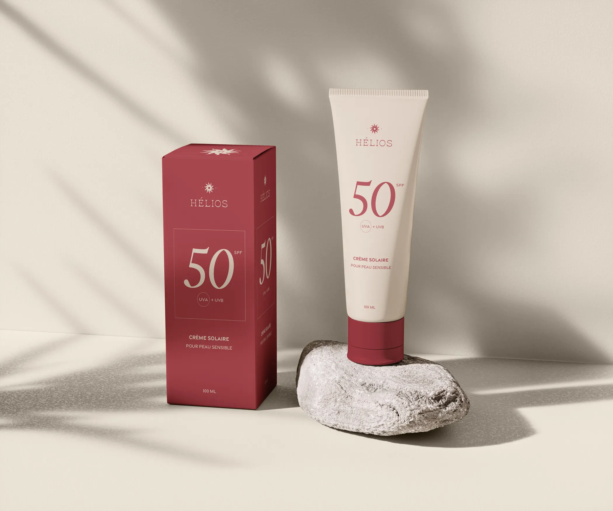 Packaging de la crème solaire SPF 50 Hélios sur un fond beige