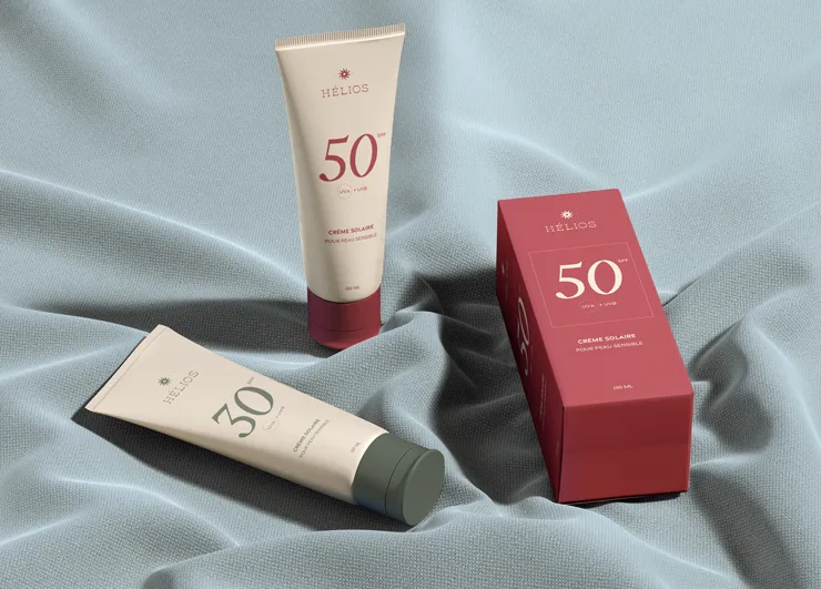 3 packaging du produit Helios posés sur un drap.
